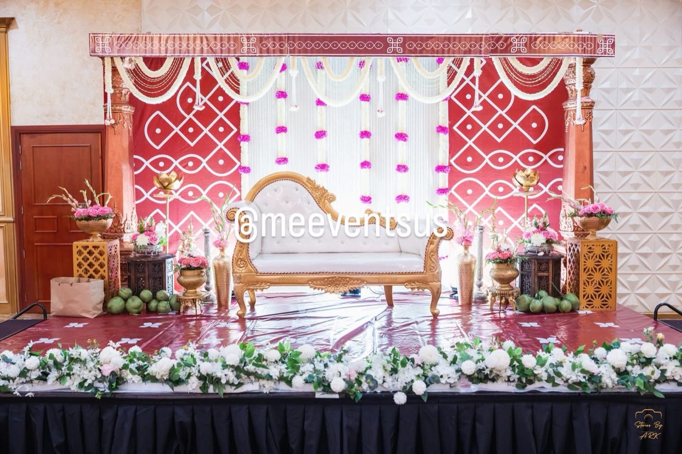 Reception stage with kolam backdrop and gold settee