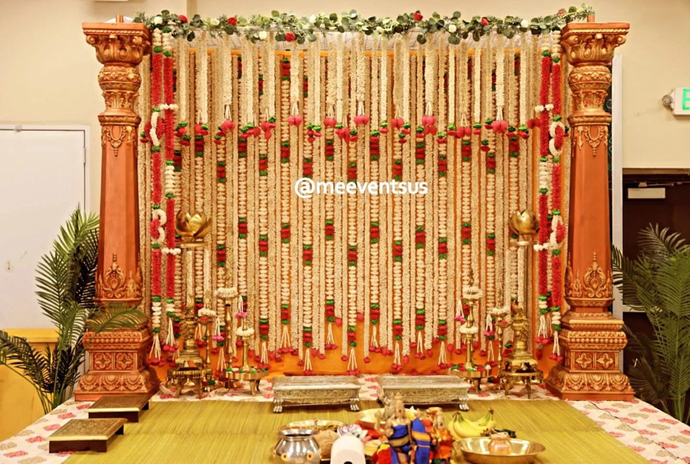 Floral garland backdrop with copper pillars