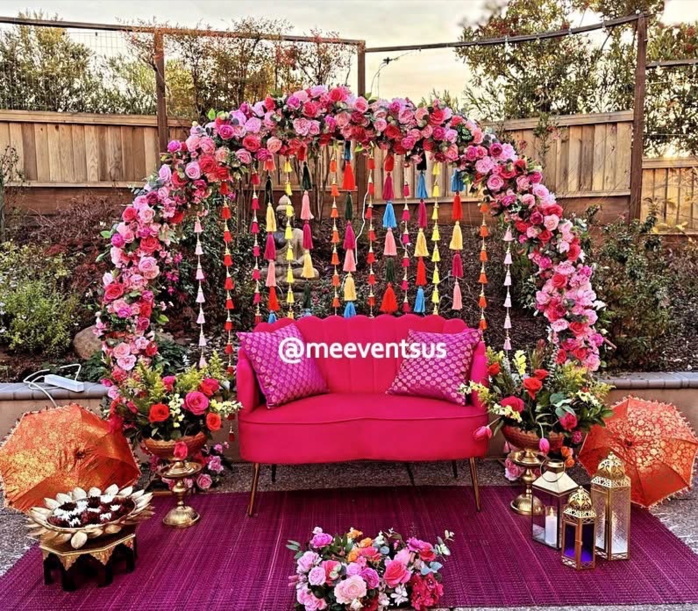Pink floral arch with sofa and tassels