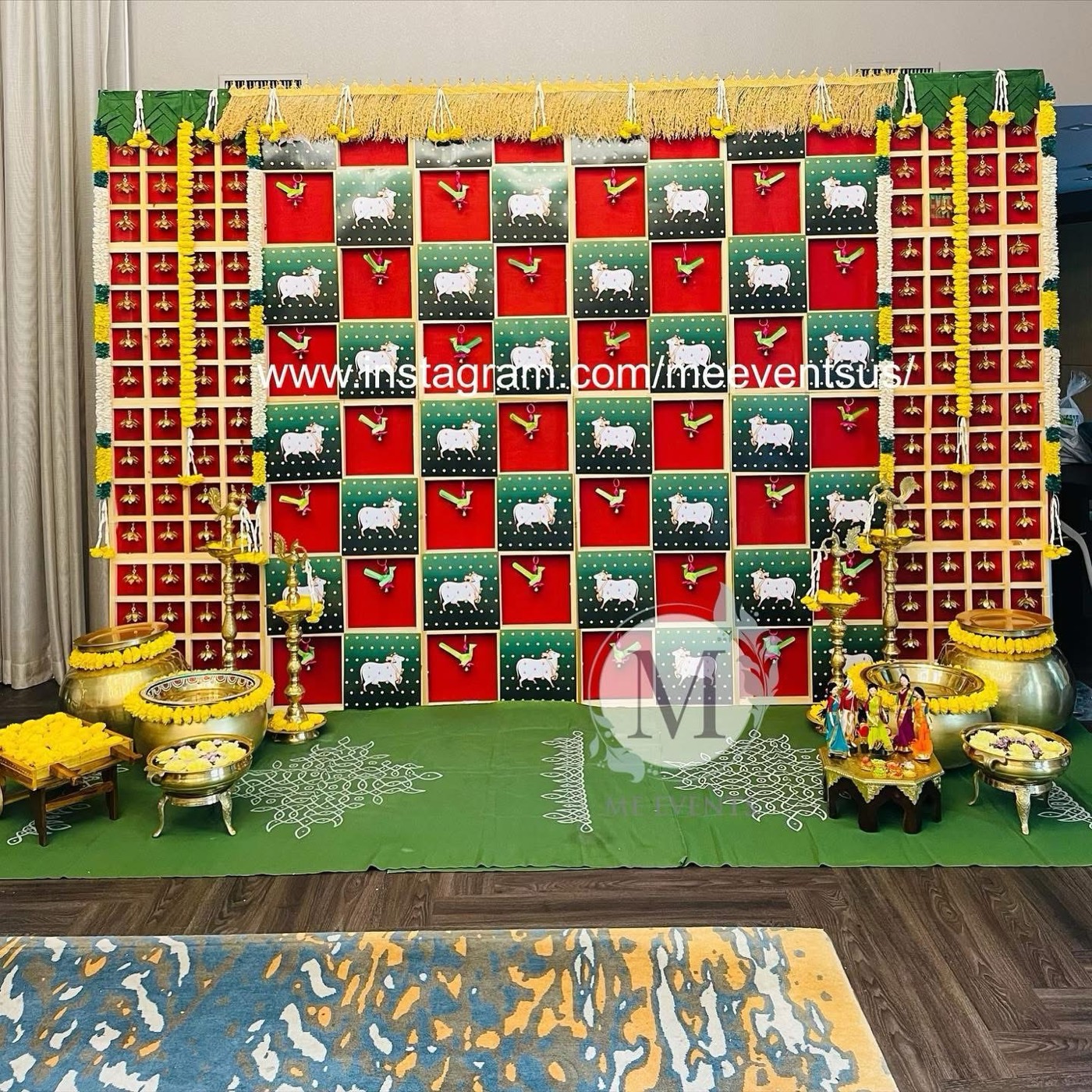 Pichwai cow-print backdrop with brass lamps
