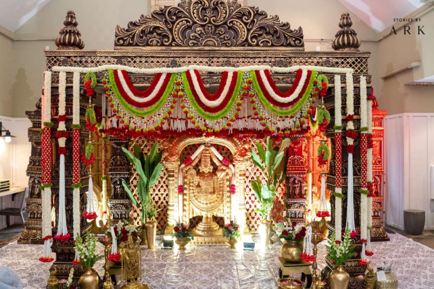 Carved wooden mandap with Balaji idol and garland swags