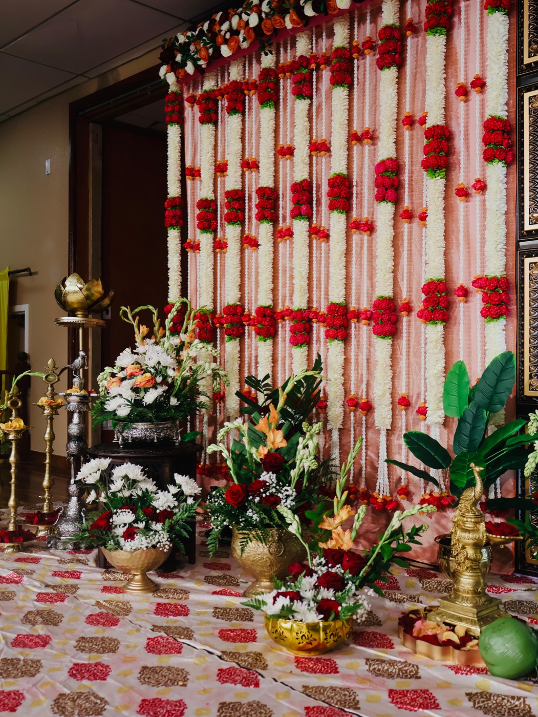 Red and white garland backdrop with brass lamps