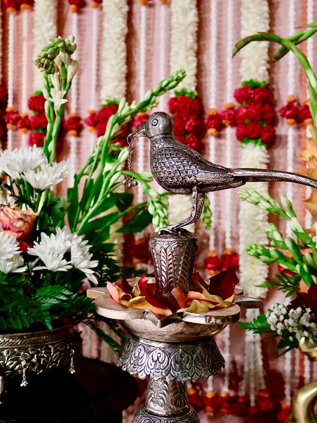 Silver bird lamp detail against floral backdrop